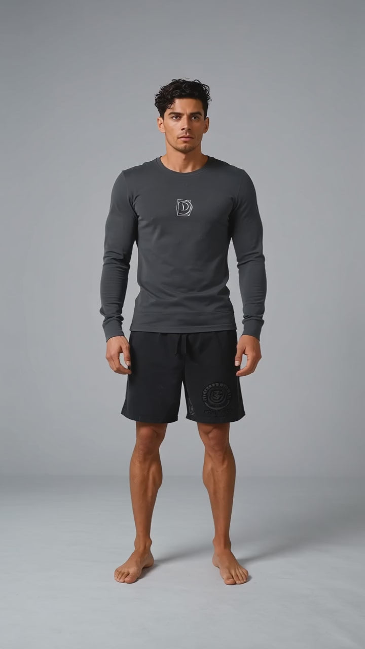 Model wearing the black DOMIN8NY Crown long-sleeve T-shirt, front view