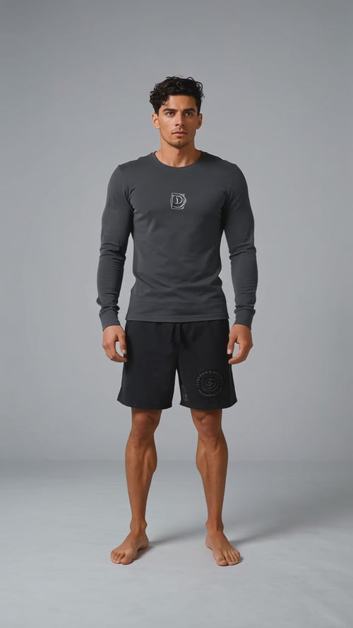 Model wearing the black DOMIN8NY Crown long-sleeve T-shirt, front view